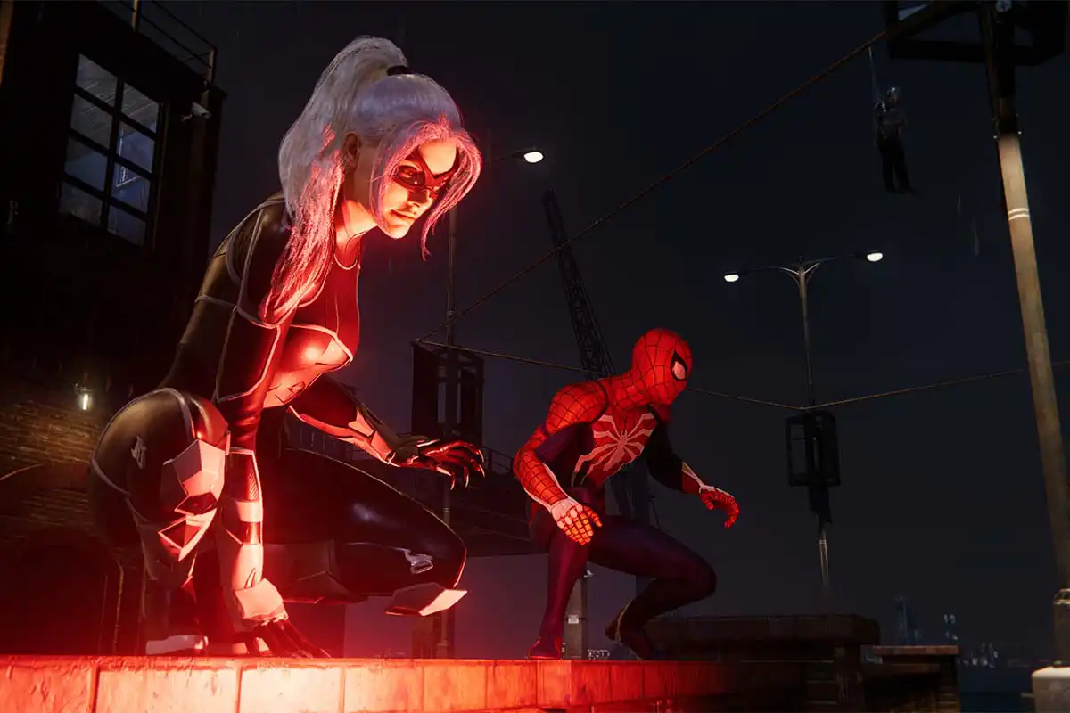 A HD screenshot from Marvel's Spider-Man Remastered showing Black Cat / Felicia Hardy with Spider-Man / Peter Parker perched on a wall over a red light