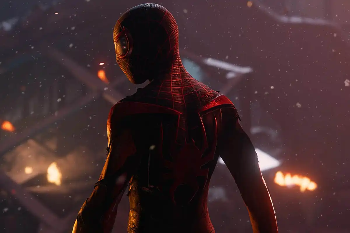 A cinematic image screenshot from Marvel's Spider-Man Miles Morales, Spider-Man / Miles Morales can be seen wearing a damaged suit with his back turned to the camera and face directing to the side